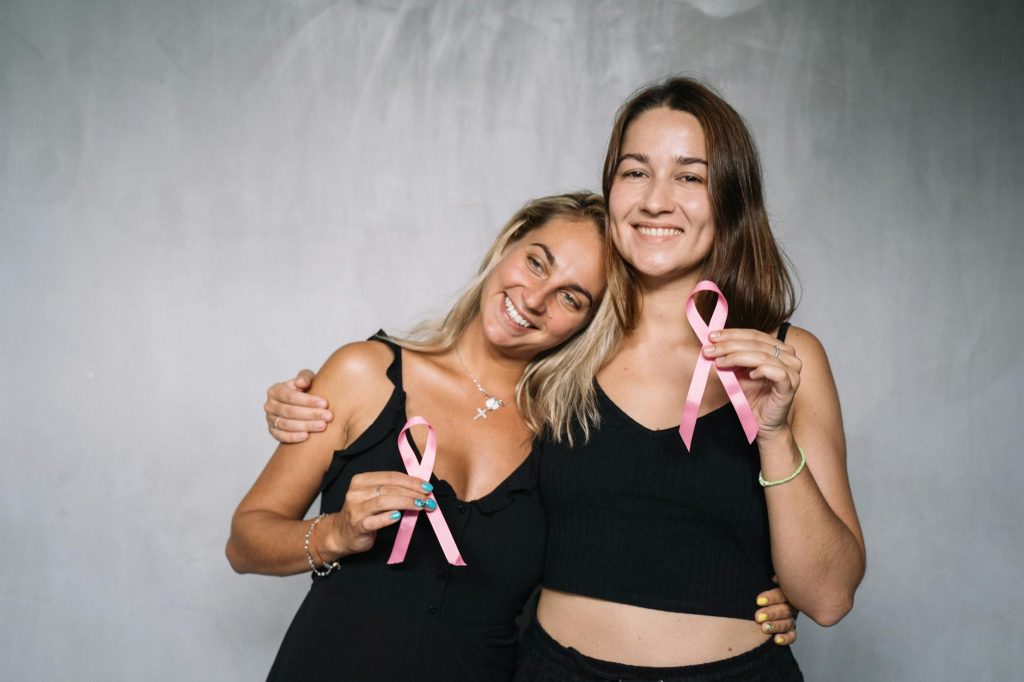 women in black tank top holding pink ribbons